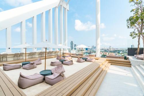 - un balcon avec des chaises et des parasols dans un bâtiment dans l'établissement Arbour Hotel and Residence, à Pattaya