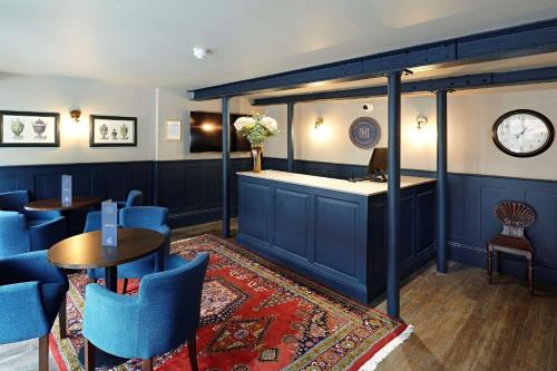 un bar con mesas y sillas azules en un restaurante en The Merchant's House, BW Signature Collection, en Salisbury