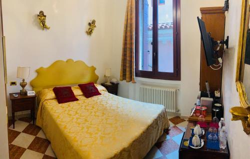 sypialnia z żółtym łóżkiem i oknem w obiekcie Luxury Venetian Rooms w Wenecji