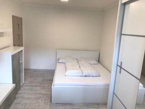 Habitación blanca pequeña con cama. en Apartmán blízko centra, en Humenné