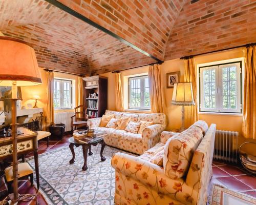 een woonkamer met 2 banken en een bakstenen muur bij Quinta Da Torre - Óbidos Country House in Óbidos