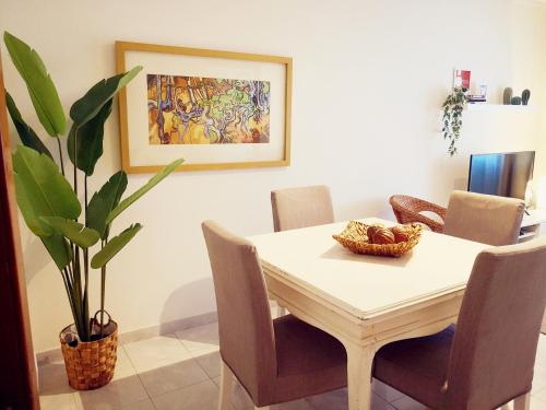 uma mesa de jantar com cadeiras e uma planta em 3B flat em Portimão