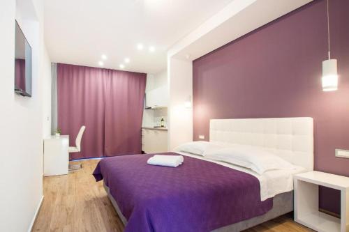 una camera con un letto con una parete viola di Luxury rooms Beach Mediteran a Podstrana