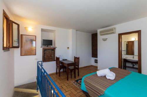 a bedroom with a bed and a table in a room at Residenza d'Epoca Pietra Di Ponente in Ciampino