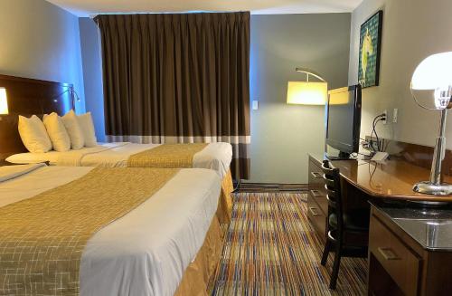 Travelodge by Wyndham Bloomington tesisinde bir odada yatak veya yataklar