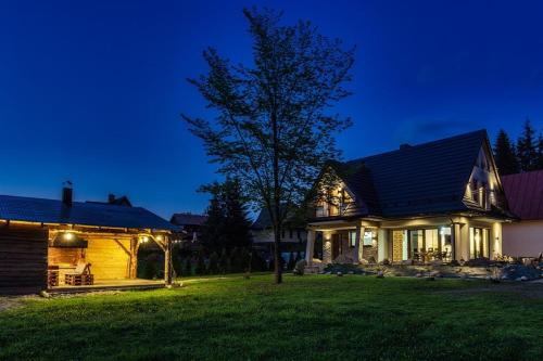 een huis met lichten op een tuin 's nachts bij Zbójowa Chata in Poronin