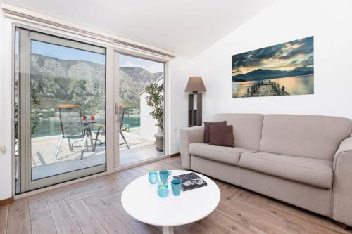 a living room with a couch and a table at De Lux Apartments Sirena in Kotor