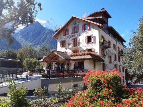 um edifício com flores em frente a uma montanha em Aiguille du Midi - Hôtel & Restaurant em Chamonix-Mont-Blanc