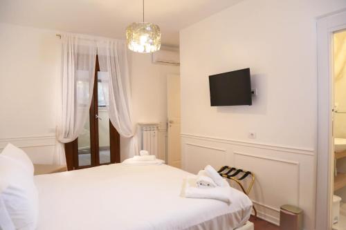 a bedroom with two beds and a tv on the wall at Mama House Roma in Rome