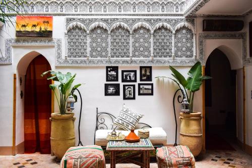 ein Wohnzimmer mit einem Tisch und Stühlen in der Unterkunft Riad Vis Ta Vie in Marrakesch