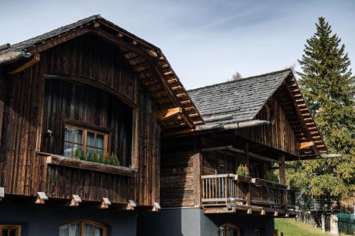 a wooden house with a balcony on the side of it at Sportony Mountain Lodges in La Villa