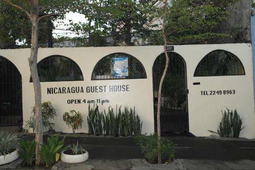 ein Schild für eine Pension mit Toren für Mikroorganismen in der Unterkunft Hostal Nicaragua Guest House in Managua