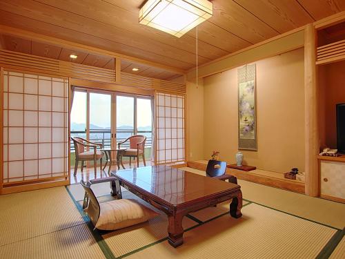 a living room with a table and a dining room at Ryokan Biyunoyado in Yamanouchi