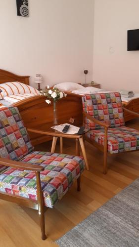 a bedroom with a bed and two chairs and a table at Apartment and rooms"Tabašnice"Tuzla centar in Tuzla