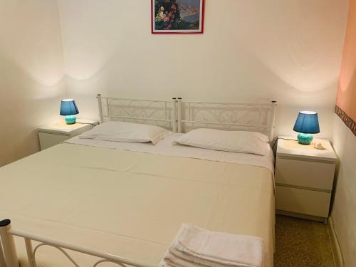 a bedroom with a white bed with two night stands at A Casa di Margy in Ravello