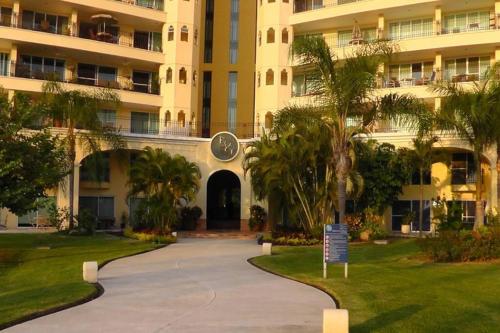 a building with a walkway in front of a building at Paradise apartment, private beach condo Bay View Grand in Puerto Vallarta