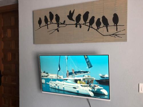 een tv aan een muur met vogels aan een tak bij Finca Las Campanas II in Villanueva de la Concepción