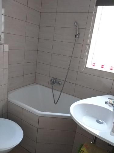 een badkamer met een bad en een wastafel bij Nefelejcs Nyaraló-Vendégház in Dunasziget