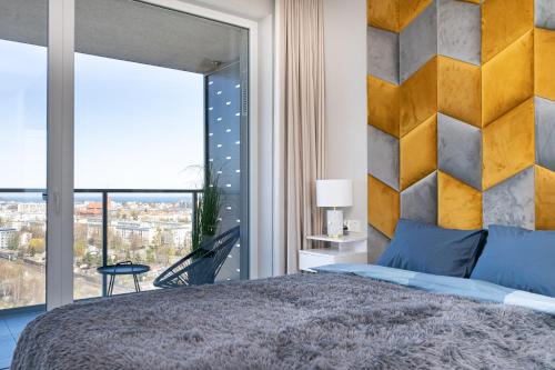 - une chambre avec un grand lit et une grande fenêtre dans l'établissement Apartament 1612 Modern Tower Gdynia, à Gdynia