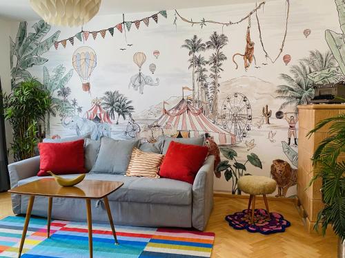 a living room with a couch and a mural of hot air balloons at Der Stadtzirkus in Klagenfurt