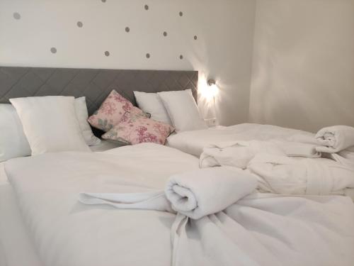 two beds with white sheets and stuffed animals on them at Spa Residence Carbona EmDoNa Luxury Apartment in Hévíz