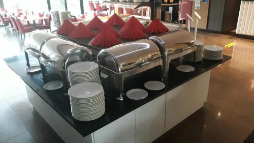 a table with plates and utensils on a counter at Mátyás Apartmanház in Gyula