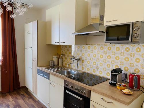 a kitchen with a sink and a microwave at Der Stadtzirkus in Klagenfurt