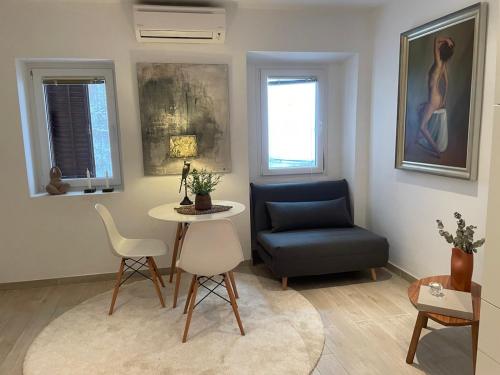 sala de estar con mesa y silla azul en Noelle apartment, en Rovinj