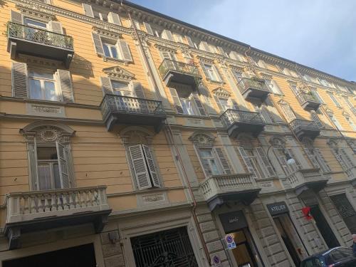 un grande edificio giallo con finestre e balconi di Maria Vittoria House a Torino