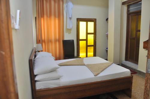 Plumeria Motel - Stone Town Zanzibar tesisinde bir odada yatak veya yataklar