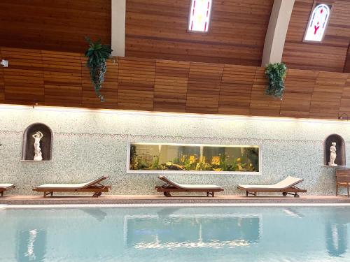 a swimming pool in a building with benches around it at Spa Residence Carbona Royal Suites 1.11 in Hévíz