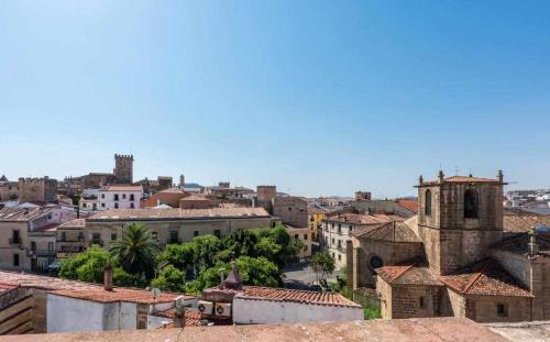 Blick auf eine Stadt mit Gebäuden und einer Kirche in der Unterkunft KubiK HOTEL in Cáceres