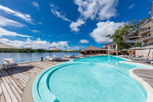 uma grande piscina com cadeiras e água em Ramada Resort by Wyndham Port Vila em Port Vila