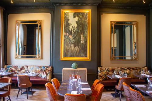 une salle à manger avec des tables, des chaises et des miroirs dans l'établissement White Hart Hotel & Apartments, à Harrogate