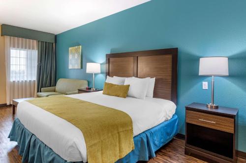 een groot bed in een hotelkamer met blauwe muren bij Best Western Plus Galveston Suites in Galveston