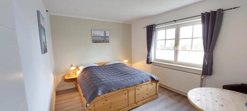 een slaapkamer met een bed en een raam bij Boddenhus auf Rügen - Ferienwohnungen und Pension in Rappin