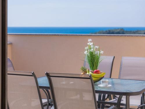 d'une table, de chaises et d'un vase de fleurs sur le balcon. dans l'établissement Apartment Joy by Interhome, à Pula