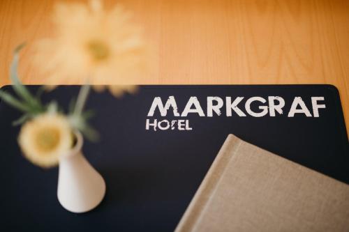 een bord voor een Marriott hotel met een vaas en een boek bij Hotel Markgraf in Klosterneuburg