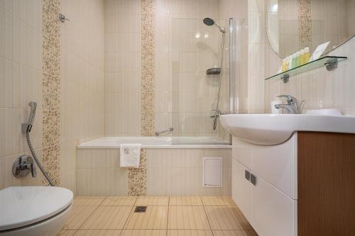 bagno con lavandino, vasca e servizi igienici di Greguar Hotel by UHM a Kiev