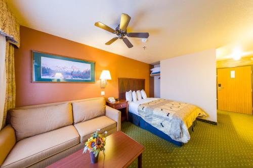 a hotel room with a bed and a couch at Alpine Inn & Suites Gunnison in Gunnison