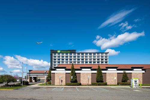 Holiday Inn Newark International Airport في نيوآرك: مبنى امامه موقف سيارات