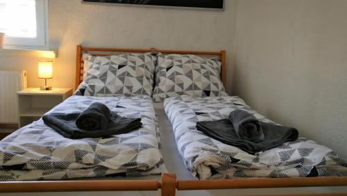 a bed with two sheets and towels on it at Apartment am Südpark in Merseburg