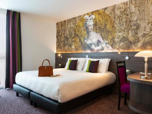 una habitación de hotel con una cama grande y una pintura en la pared en Hôtel Roi Soleil Prestige Plaisir - St Quentin, en Plaisir