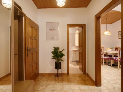 a hallway with a door and a potted plant at Goldengel Ferienwohnung im Herzen Kalterns mit einer Terasse zum verlieben in Caldaro