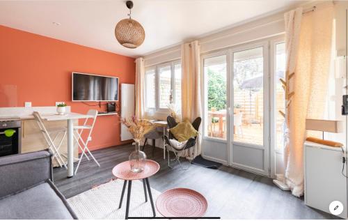 sala de estar con paredes de color naranja y mesa en Le 102, Maison avec Terrasse et parking Gare de ROUEN, en Rouen