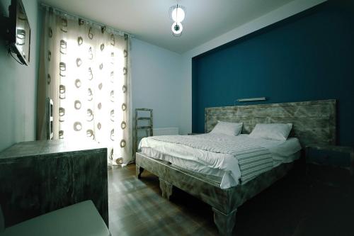 1 dormitorio con cama y pared azul en Hotel Kutaisi Globus, en Kutaisi