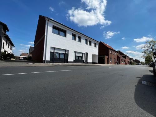 um edifício branco ao lado de uma rua em kleines boardinghouse em Nordwalde