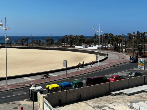 uma estrada com praia e carros na rua em Casa City em Arrecife