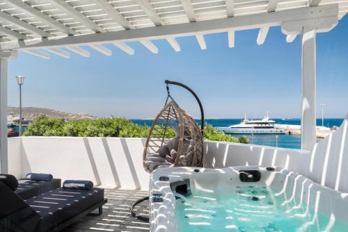 een hot tub op een patio met uitzicht op de oceaan bij Riva Suites - Adults Only in Mykonos-stad