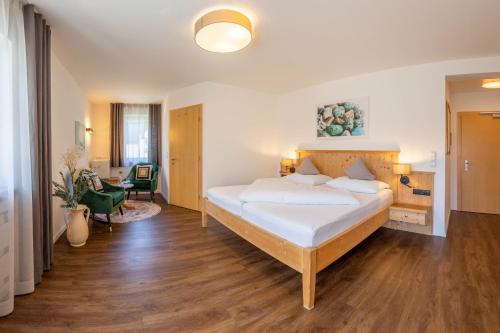 ein Schlafzimmer mit einem großen weißen Bett in einem Zimmer in der Unterkunft Wohlfühlhotel Mei Auszeit in Plaus